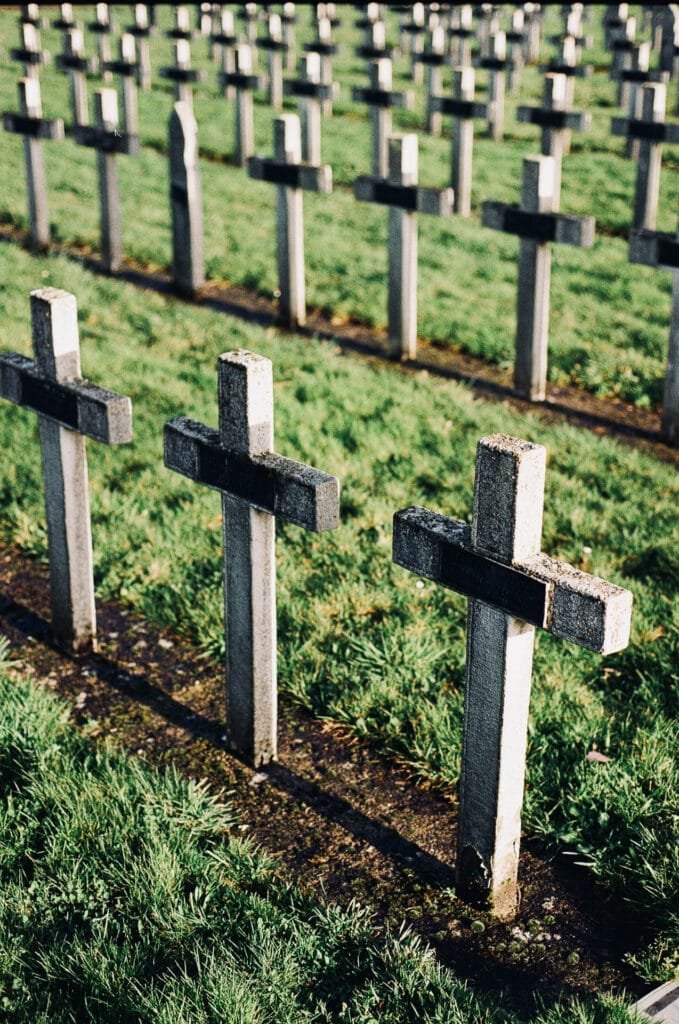 Croix alignées dans un cimetière militaire à Nantes, éclairées par une lumière rasante.