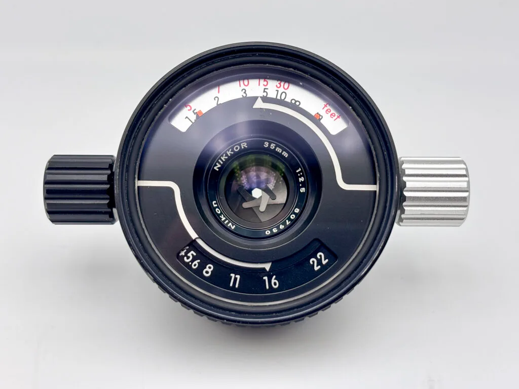 Objectif Nikkor 35 mm f/2.5 pour Nikonos avec échelle de distances et réglage de l’ouverture visibles.