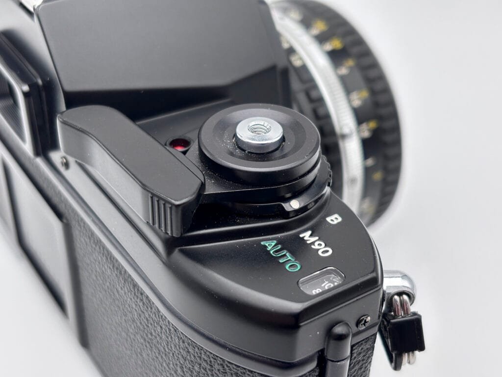 Détail du sélecteur AUTO M90 B sur le Nikon EM montrant les différents modes d’exposition.