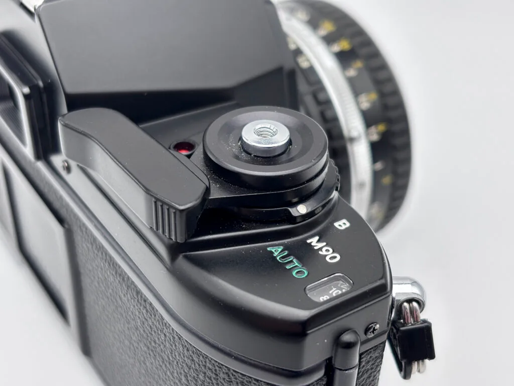 Détail du sélecteur AUTO M90 B sur le Nikon EM montrant les différents modes d’exposition.