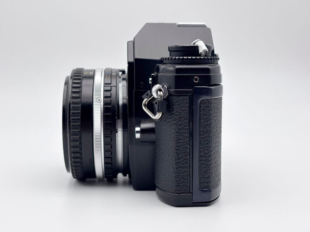 Vue latérale du Nikon EM montrant la finesse du boîtier et l’objectif Series E monté.