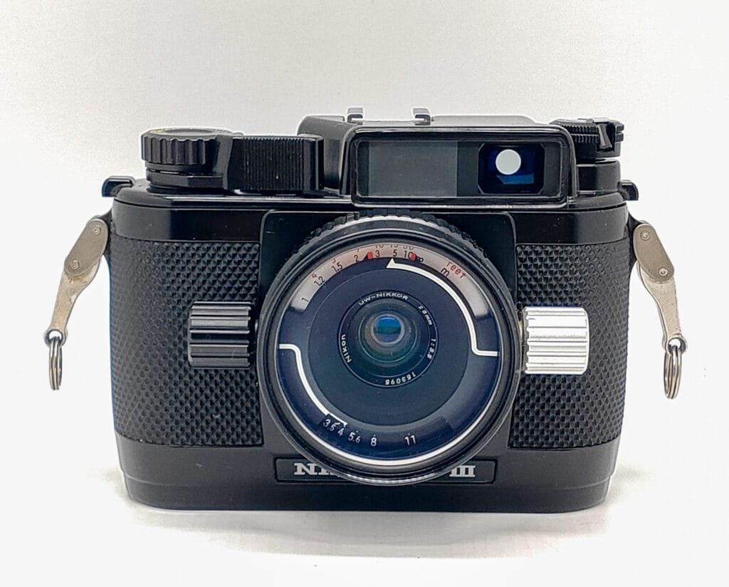 Appareil photo argentique Nikonos III, boîtier étanche entièrement mécanique, vu de face avec objectif Nikkor dédié à la plongée.
