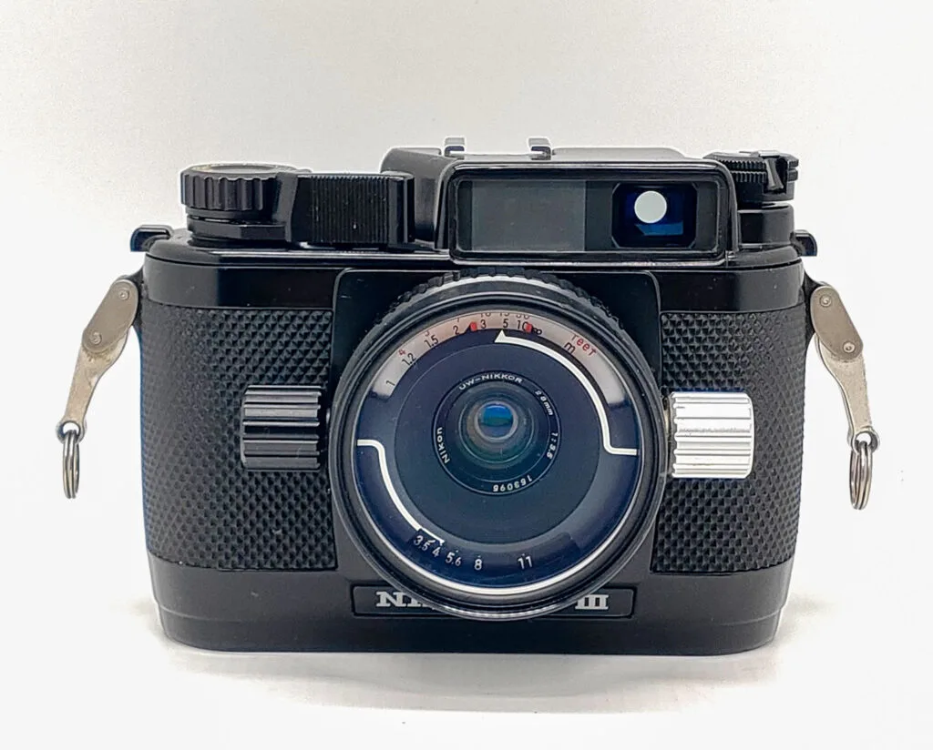 Appareil photo argentique Nikonos III, boîtier étanche entièrement mécanique, vu de face avec objectif Nikkor dédié à la plongée.