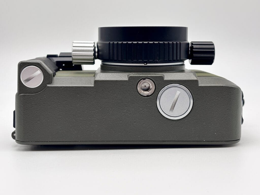 Dessous du Nikonos V montrant le logement de la batterie, le pas de vis pour trépied et la prise synchro flash.