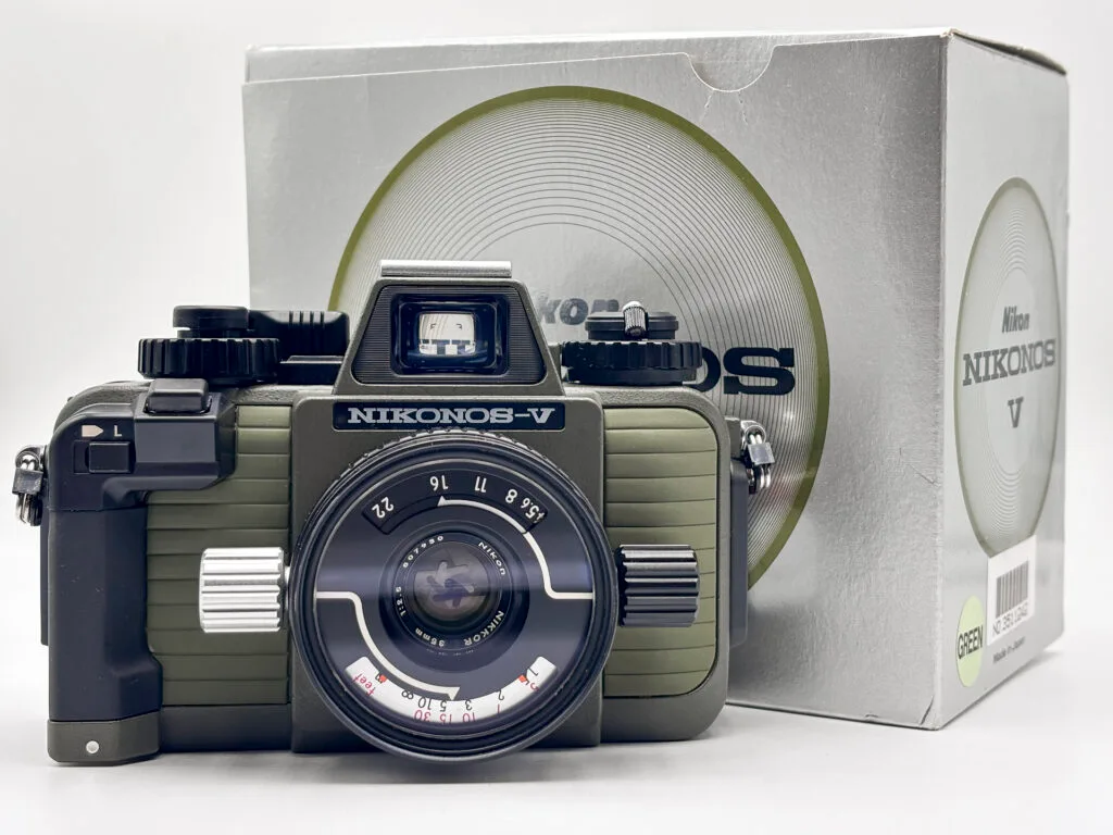 Appareil photo argentique Nikonos V avec objectif W-Nikkor 35mm f/2.5, présenté avec sa boîte d’origine.