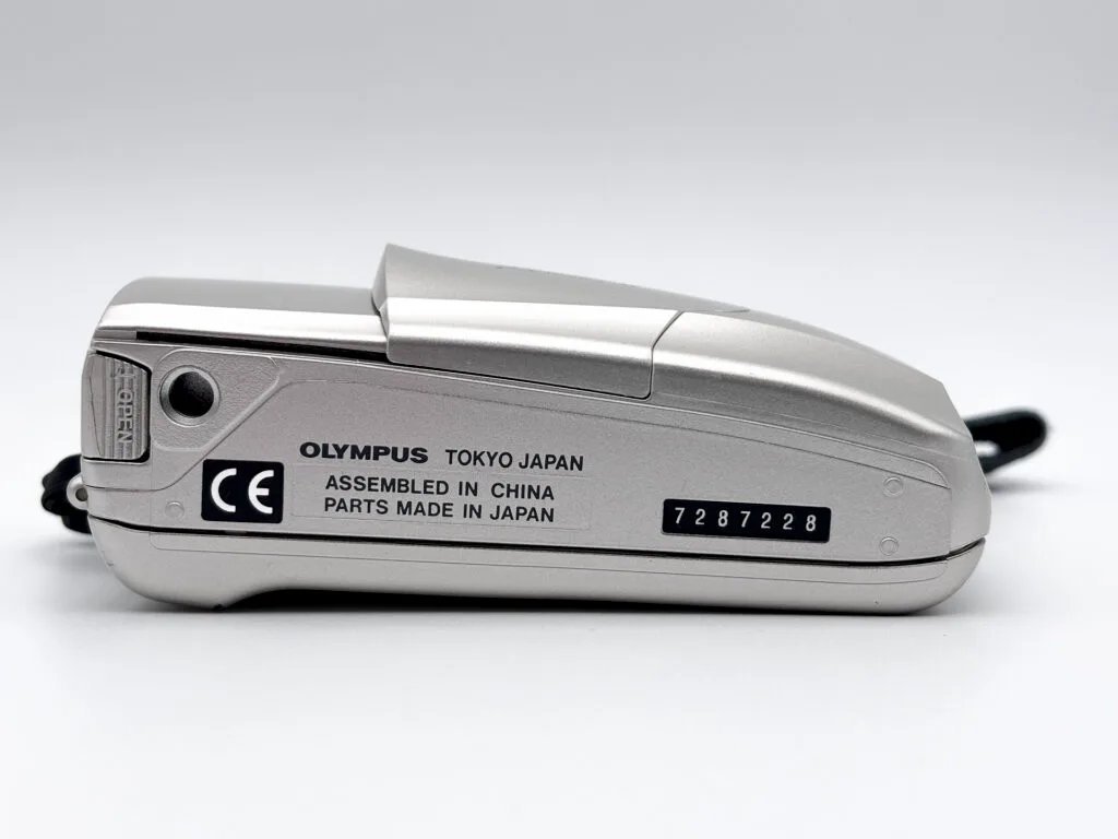 Vue de dessous d’un Olympus Mju II montrant le numéro de série et les inscriptions de fabrication.