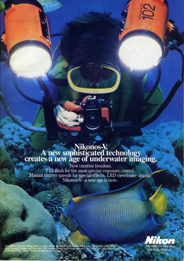Publicité Nikon pour le Nikonos V montrant un photographe sous-marin équipé de flashes, photographiant un poisson sur un récif.