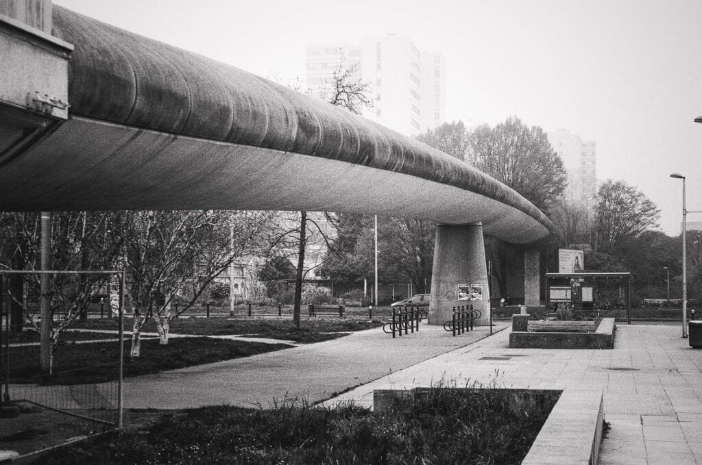 Passerelle en béton près des Choux de Créteil traversant un espace urbain avec arceaux à vélos
