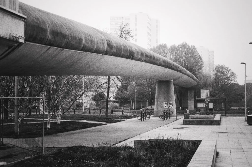 Passerelle en béton près des Choux de Créteil traversant un espace urbain avec arceaux à vélos