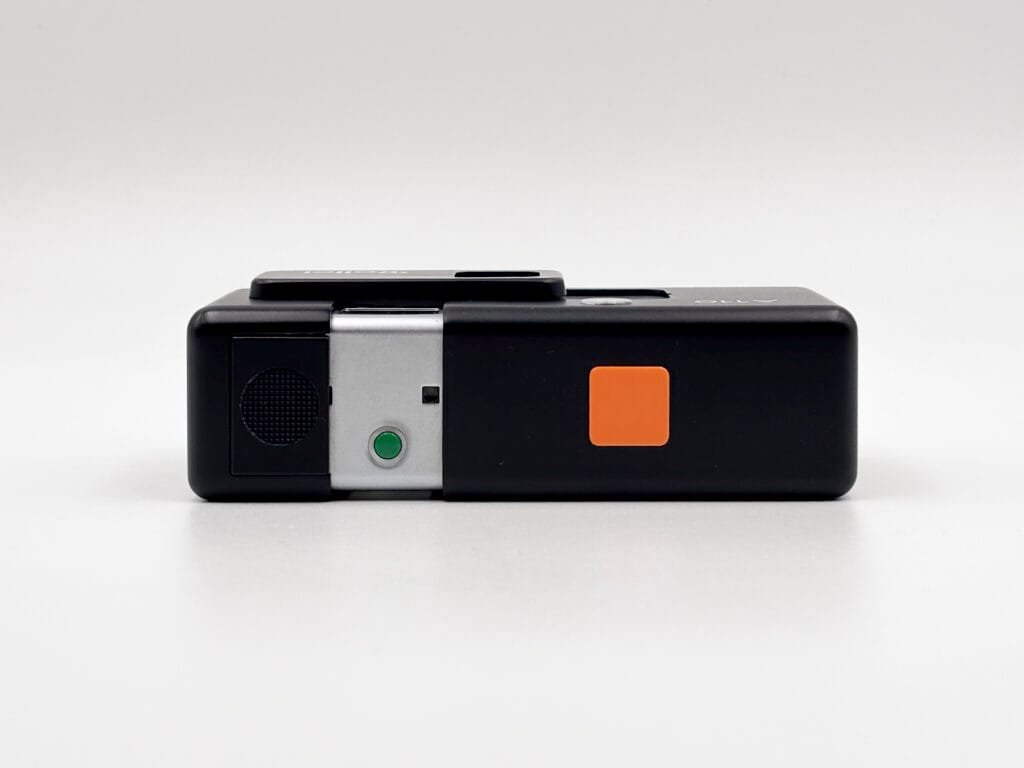 Vue du dessus du Rollei A110 avec déclencheur orange, témoin d’exposition vert et logement de la batterie