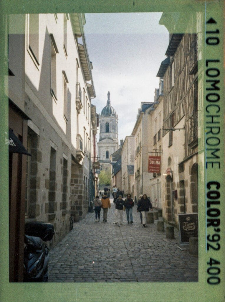 Ruelle pavée du centre historique de Rennes avec l'église Sainte-Melaine en fond, photographiée au Rollei A110 sur pellicule LomoChrome Color'92 400