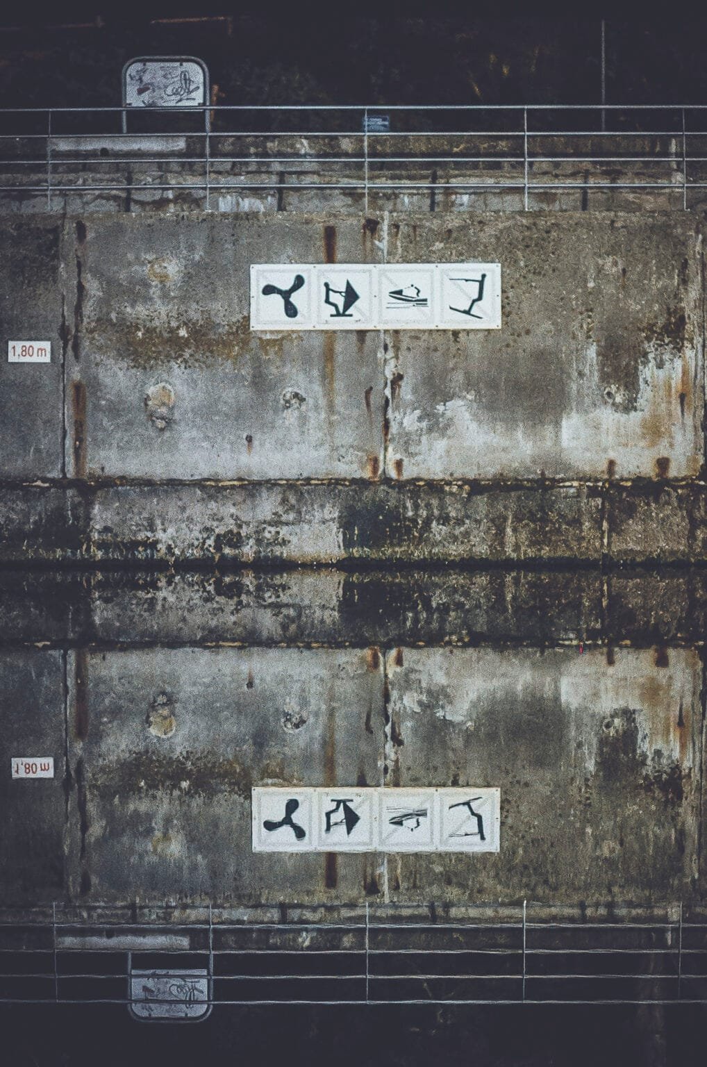 Mur en béton de la piscine du Prieuré à Dinard avec pictogrammes et indication de profondeur 1,80m, reflet dans l'eau, photo argentique Nikon F3