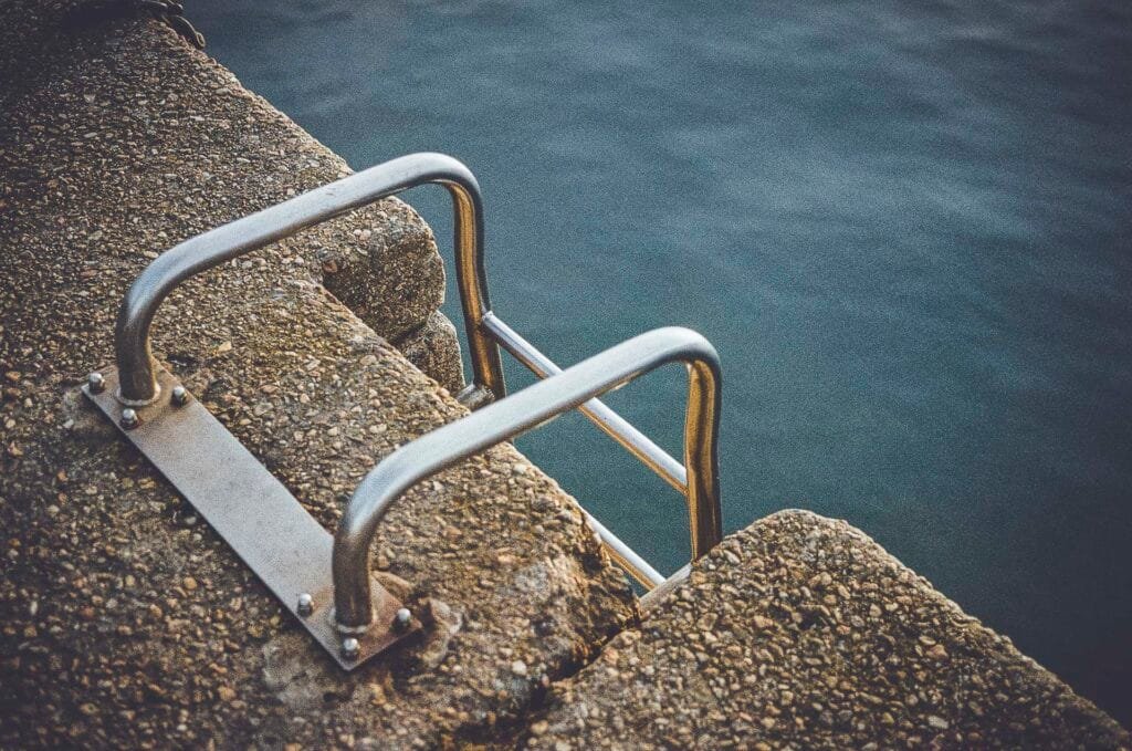 Gros plan en plongée sur une échelle métallique fixée au béton d'un quai à Dinard, photo argentique Nikon F3