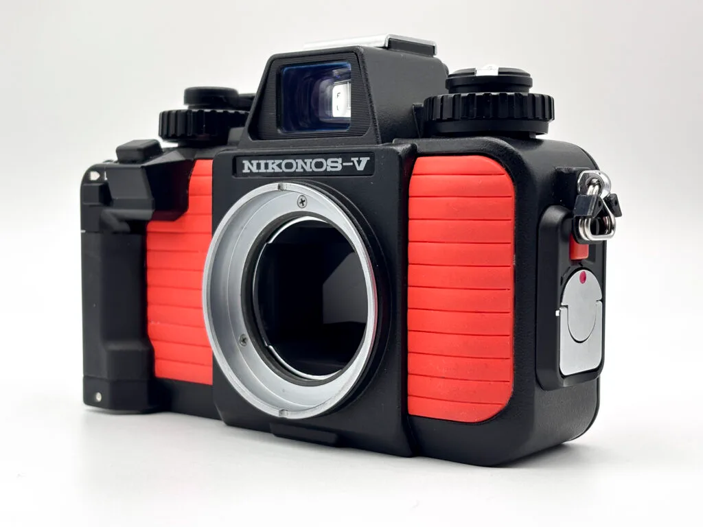 Nikonos V coloris orange boîtier nu sans objectif, vue trois quarts avant sur fond blanc