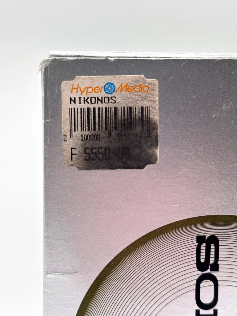 Détail de la boîte du Nikonos V orange avec étiquette revendeur HyperMedia et prix d'origine 5 550 francs