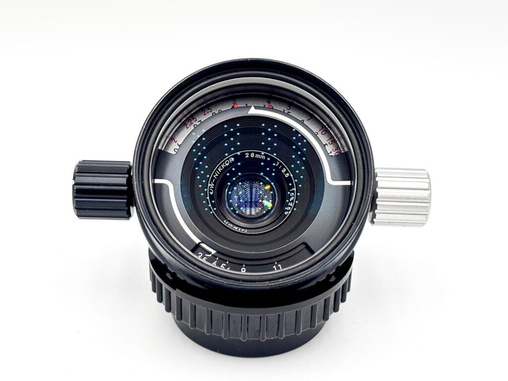 Objectif UW-Nikkor 28mm f/3.5 pour Nikonos vu de face, avec ses deux molettes de réglage ouverture et mise au point