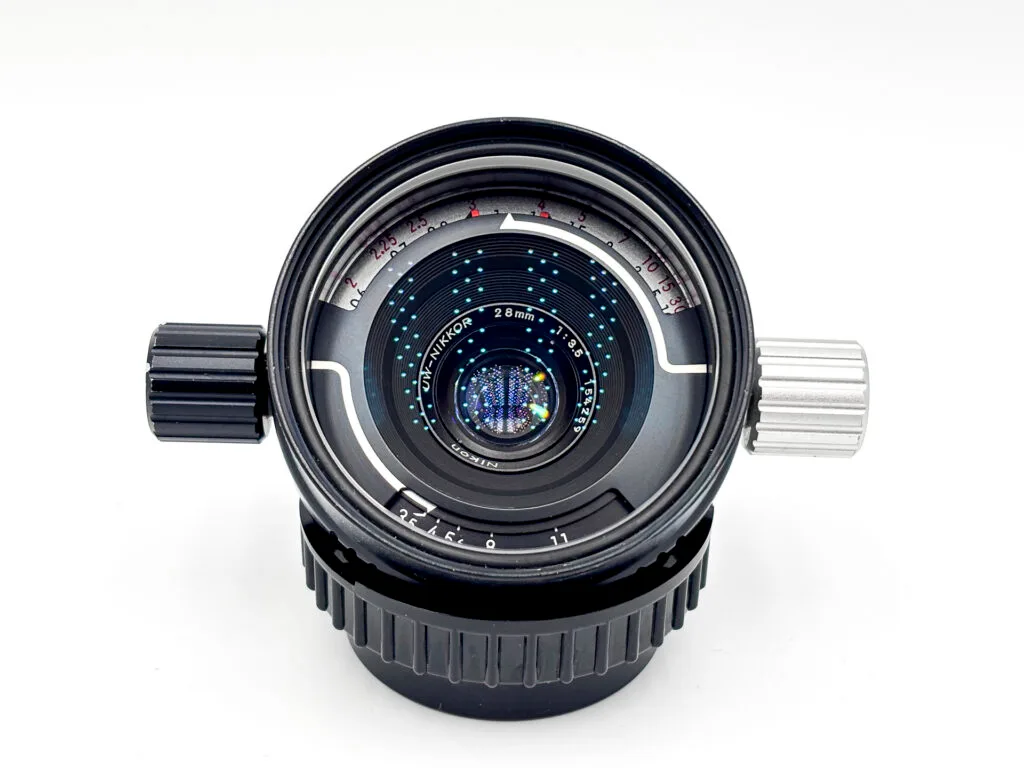 Objectif UW-Nikkor 28mm f/3.5 pour Nikonos vu de face, avec ses deux molettes de réglage ouverture et mise au point