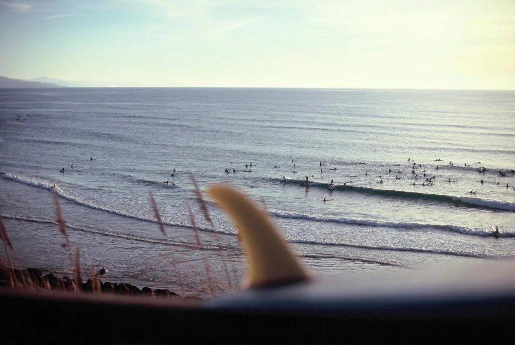 Dérive de planche en premier plan flou, line-up de surfeurs sur un spot de la côte basque, photo argentique couleur - © YannB / yannb.net