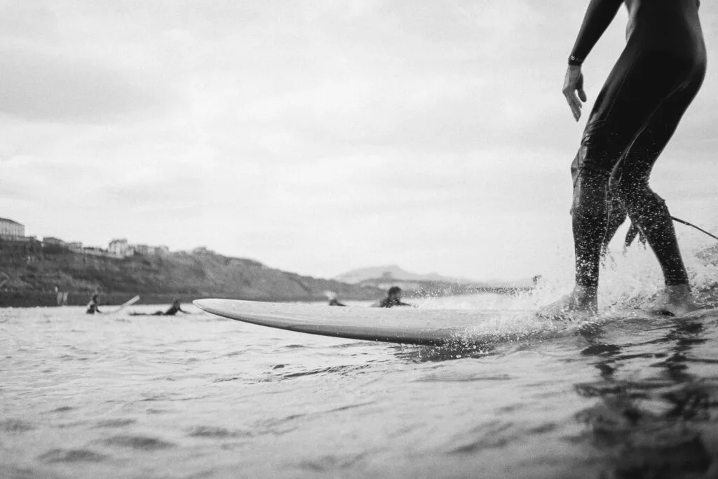 Longboarder sur sa planche devant la côte de Biarritz, photo argentique noir et blanc au Nikonos V - © YannB / yannb.net