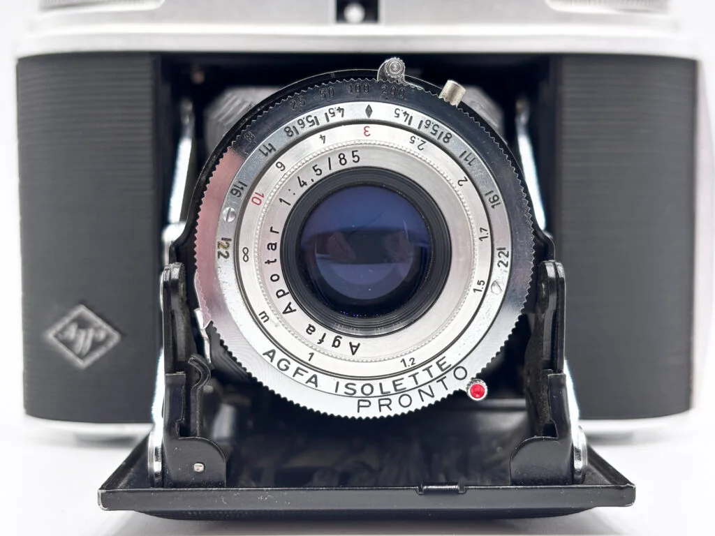 Gros plan sur l'objectif Apotar 1:4,5/85 et l'obturateur Pronto de l'Agfa Isolette II, bagues de vitesse et de distance visibles