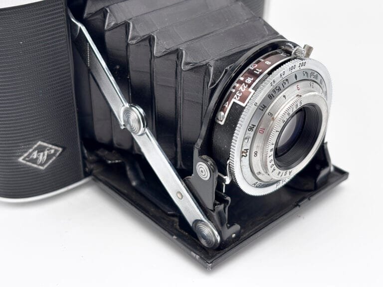 Détail de l'objectif Apotar et des bras chromés de déploiement de l'Agfa Isolette II ouvert, vue en contre-plongée