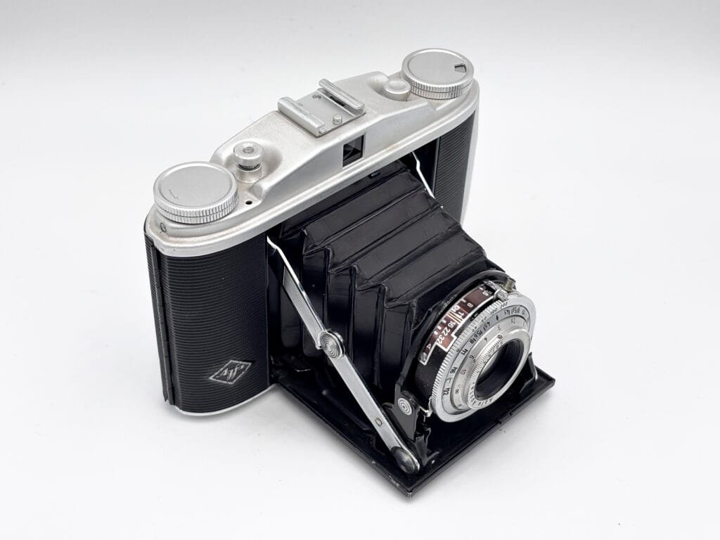 Agfa Isolette II ouvert en vue trois quarts depuis le dessus gauche, soufflet déployé, dessus du boîtier et objectif Apotar visibles