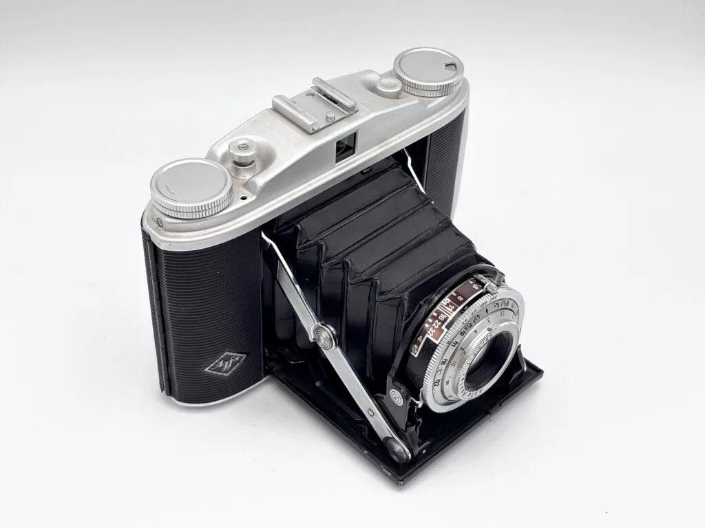 Agfa Isolette II ouvert en vue trois quarts depuis le dessus gauche, soufflet déployé, dessus du boîtier et objectif Apotar visibles