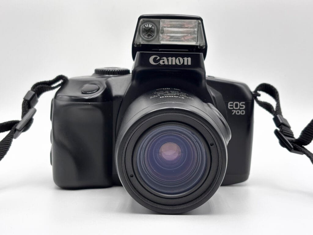 Canon EOS 700 argentique vu de face avec flash intégré relevé et zoom Canon EF 35-80mm
