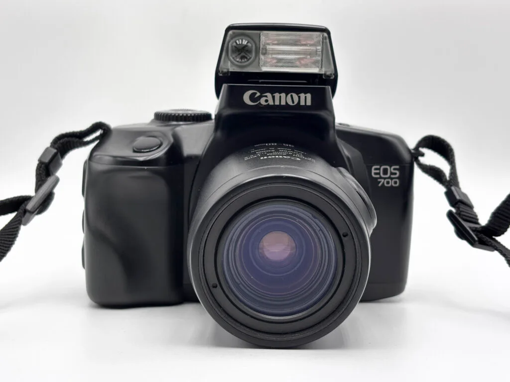 Canon EOS 700 argentique vu de face avec flash intégré relevé et zoom Canon EF 35-80mm