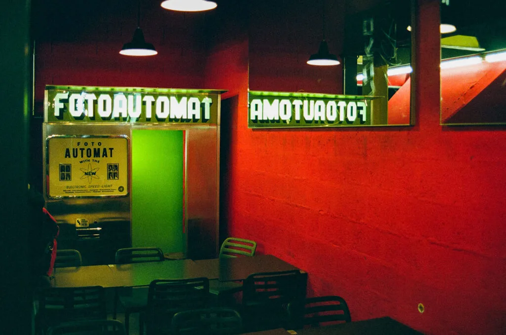 Photomaton Fotoautomat et son reflet dans un miroir dans le hall du Lieu Unique à Nantes, dominante rouge, Canon EOS 700