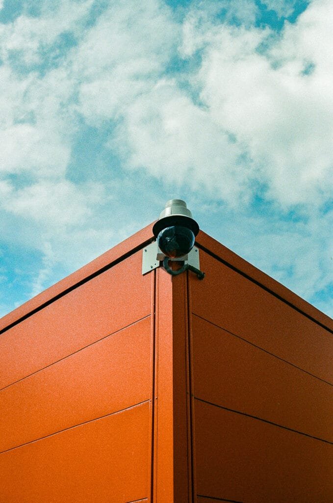 Angle d'un algeco orange avec caméra de surveillance devant le CHU de Nantes, ciel bleu nuageux, Canon EOS 700