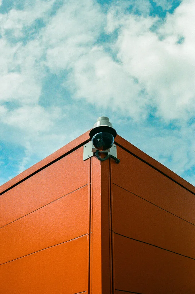 Angle d'un algeco orange avec caméra de surveillance devant le CHU de Nantes, ciel bleu nuageux, Canon EOS 700