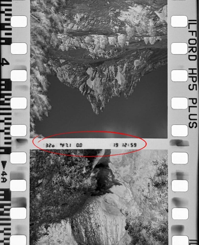 Négatif Ilford HP5 Plus montrant les données d'exposition imprimées par le Nikon F6 entre deux vues : 1/320s, f/7.1, 12h59