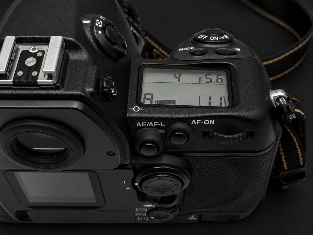 Nikon F6 — LCD supérieur affichant 1/4s f/5.6 en mode A, boutons AE/AF-L et AF-ON