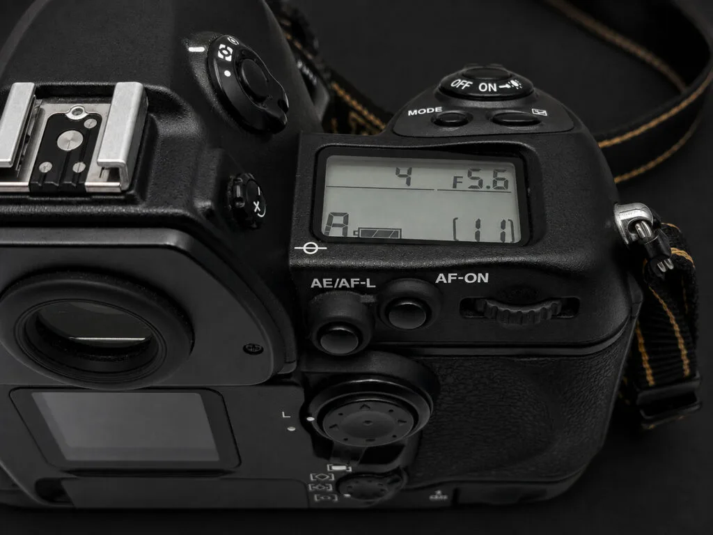 Nikon F6 — LCD supérieur affichant 1/4s f/5.6 en mode A, boutons AE/AF-L et AF-ON