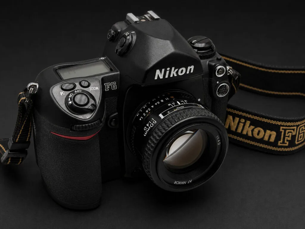 Nikon F6 et AF Nikkor 50mm f/1.4D — vue trois quarts avec courroie Nikon F6 d'origine