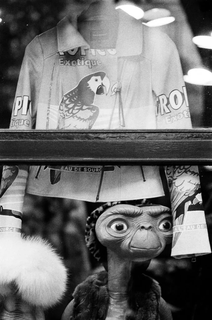 E.T. derrière une vitrine sous une veste à perroquets, près de République, Paris, Ilford HP5