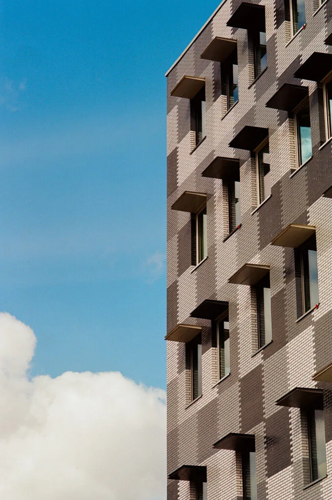 Façade en briques et nuage isolé, composition en espace négatif, Île de Nantes