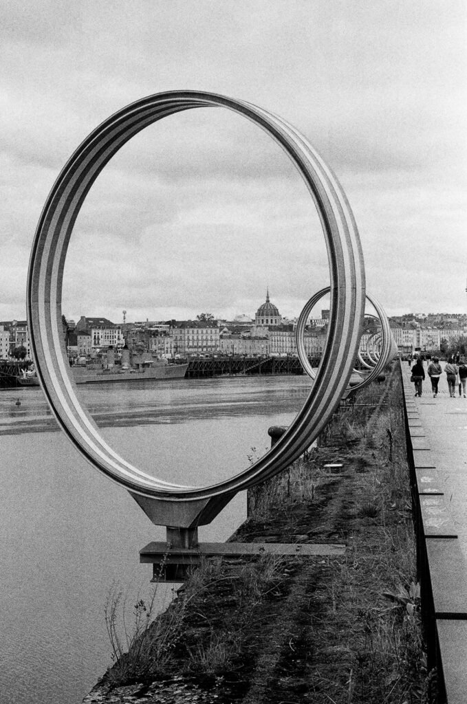 Un des Anneaux de Daniel Buren et Patrick Bouchain sur le quai des Antilles à Nantes, encadrant la Loire et le dôme de Notre-Dame-de-Bon-Port