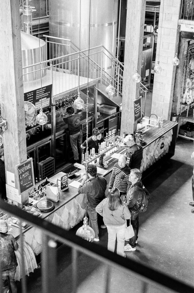 Comptoir de la Little Atlantique Brewery au Bas-Chantenay à Nantes vu depuis la mezzanine, avec clients, serveurs et cuves de brassage en inox
