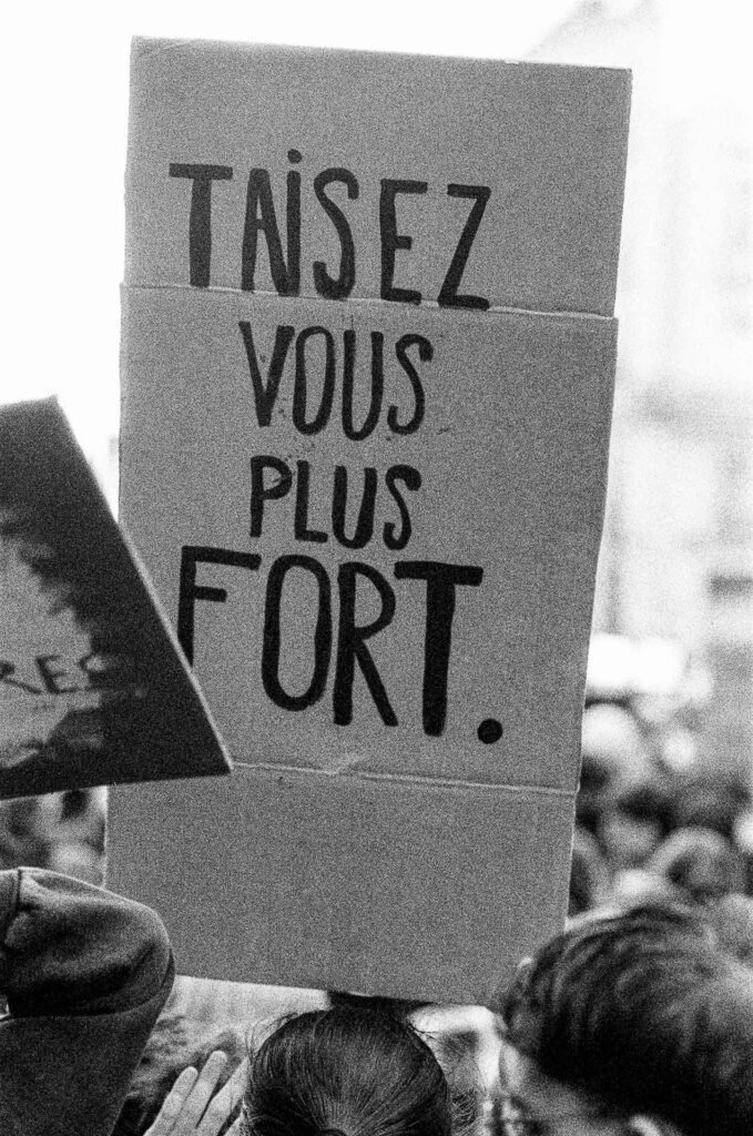 Pancarte en carton « Taisez-vous plus fort » brandie au-dessus des têtes des manifestants à Nantes