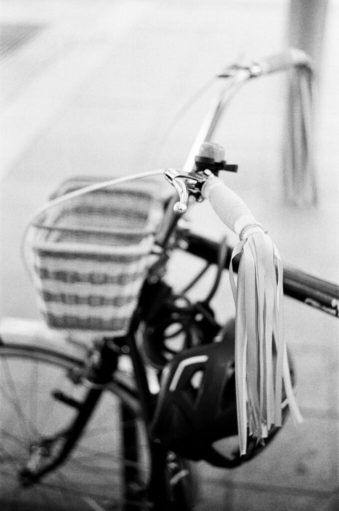 Poignée de vélo ornée de franges, nette à f/2, avec le panier et le cadre du vélo flous en arrière-plan